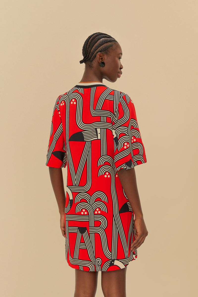 Vista trasera del vestido estampado con diseño geométrico en tonos de rojo y negro.