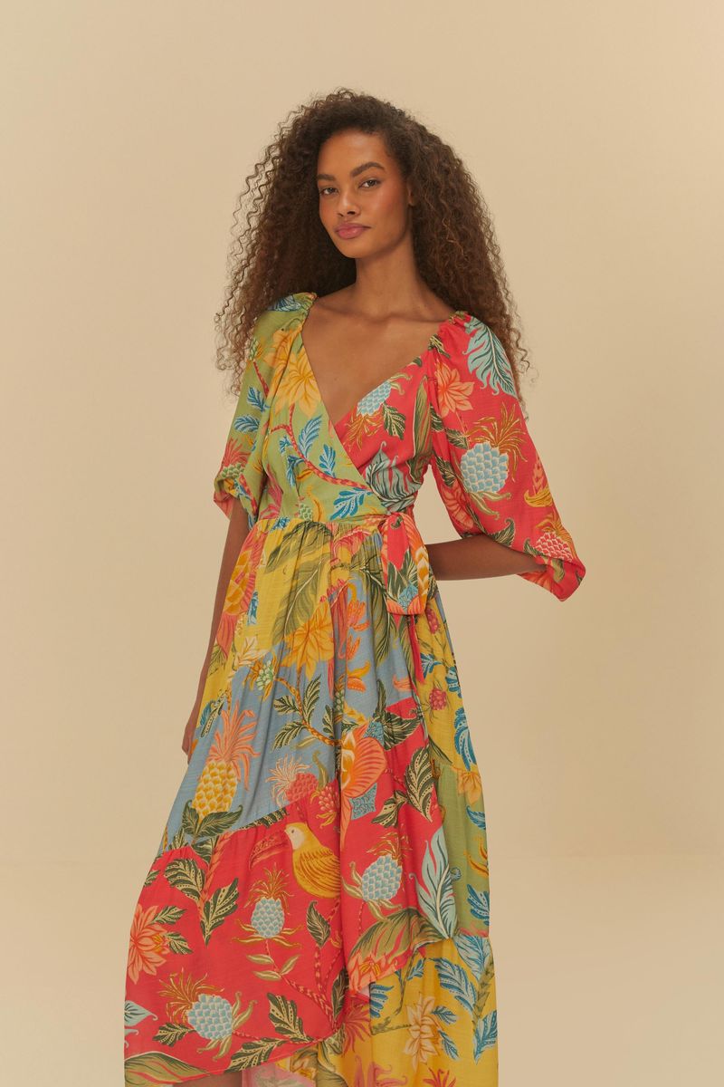 Detalle del vestido destacando el diseño tropical con elementos botánicos y frutas, además de su ajuste en la cintura.