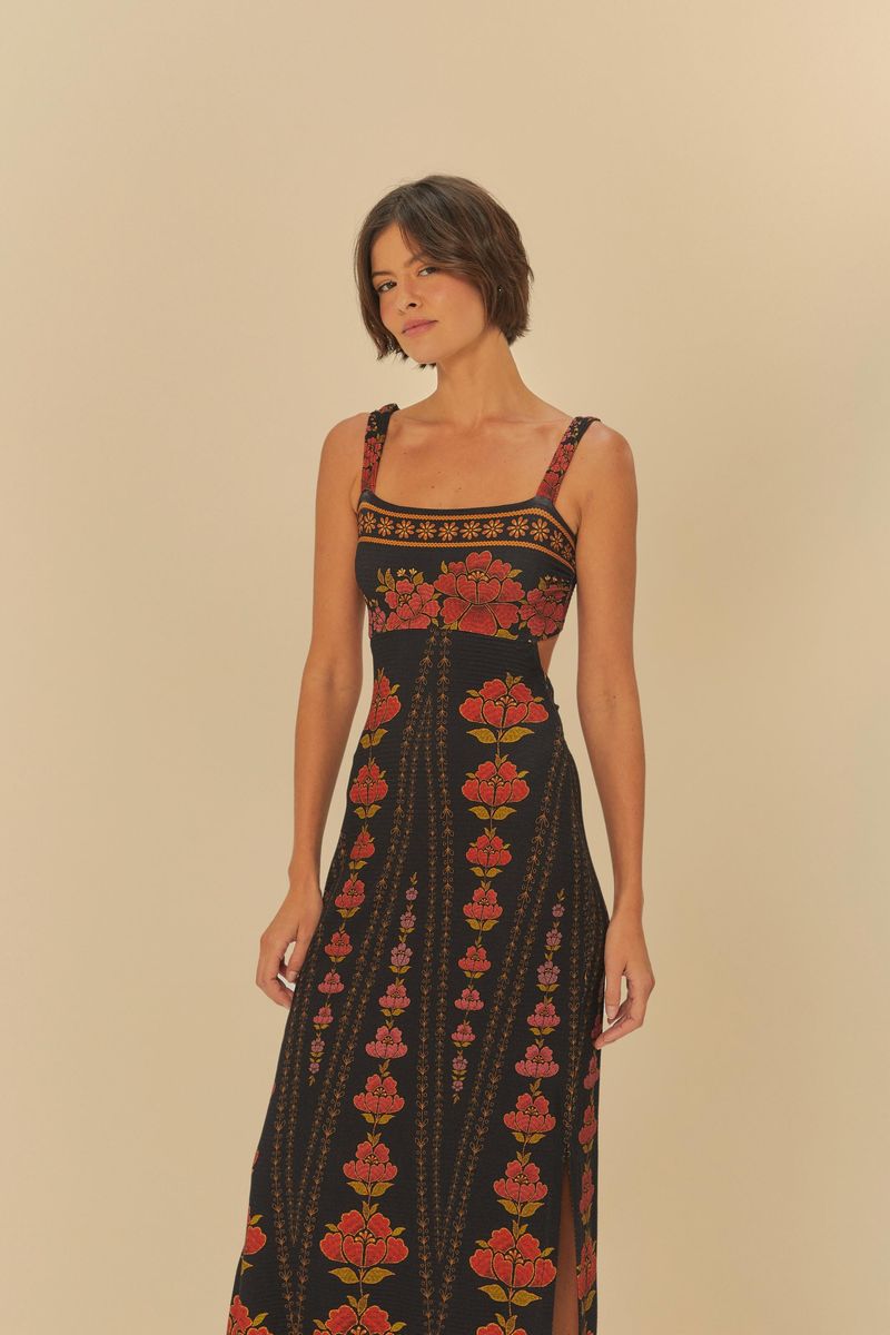 Vestido midi con estampado floral sobre fondo negro, tirantes anchos y escote cuadrado, visto de lado.