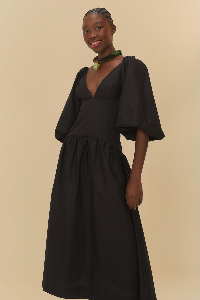 Primer plano del vestido negro con mangas largas y escote en V profundo.