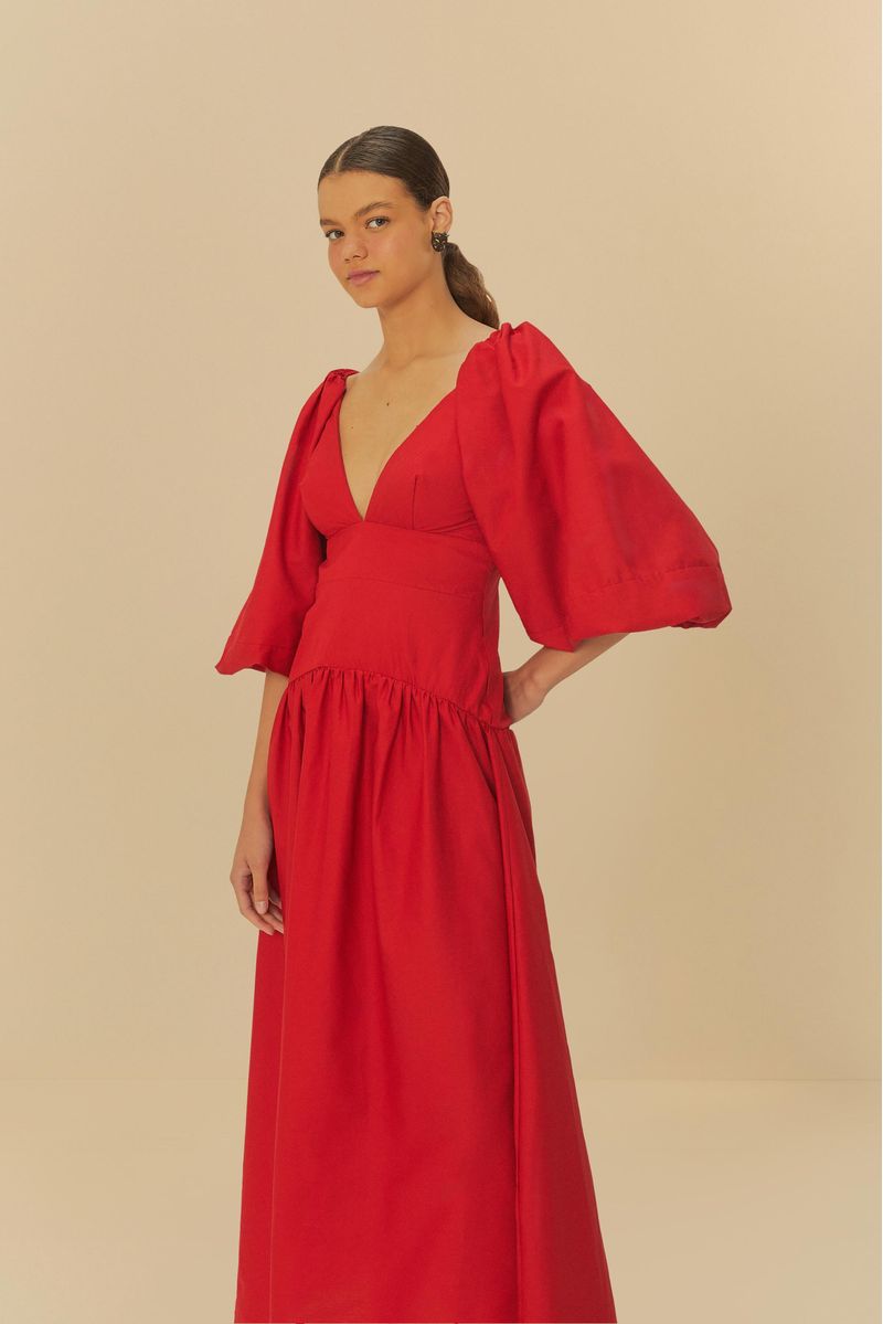 Vestido corto rojo con mangas abullonadas y escote en V, exhibido en una pose lateral.