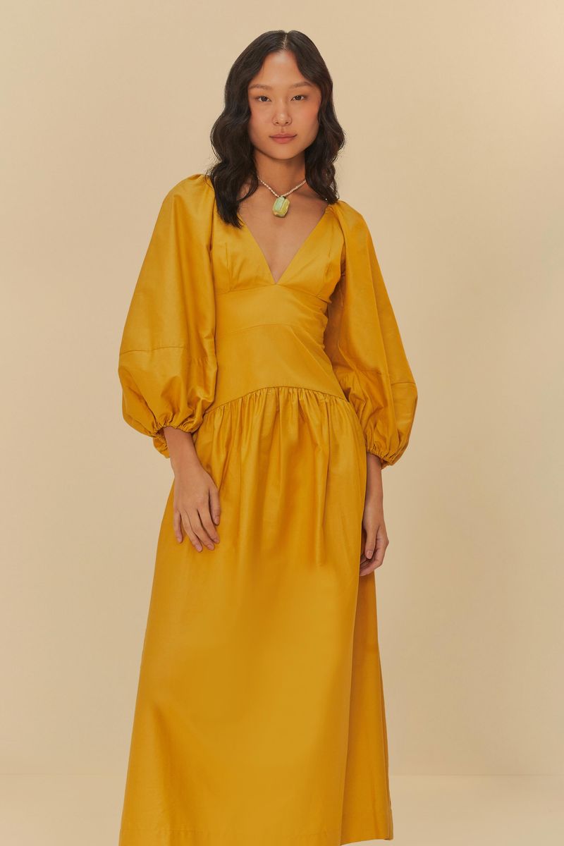 Vestido cropped con mangas abullonadas en tono amarillo, visto desde el lado.