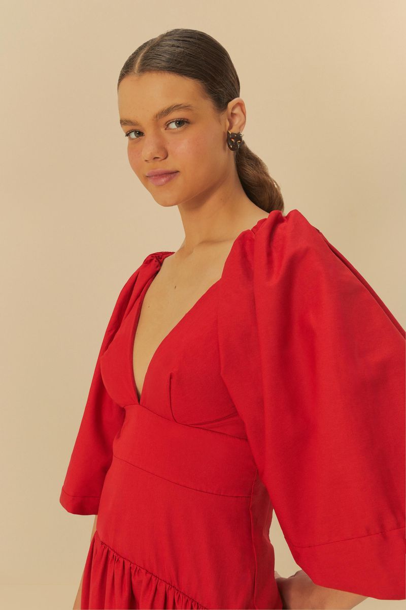 Detalle del escote en V y mangas abullonadas del vestido corto rojo.