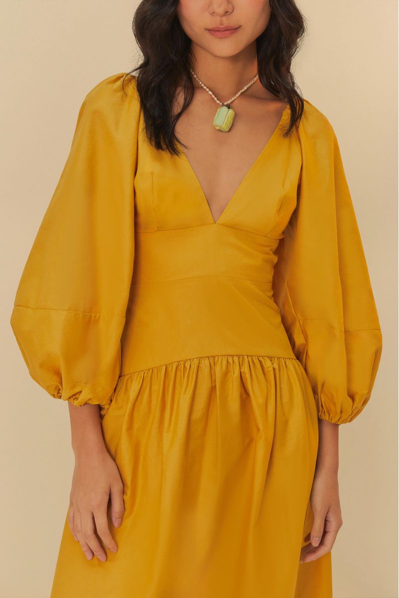Vestido cropped con mangas abullonadas en tono amarillo, detalle del escote.