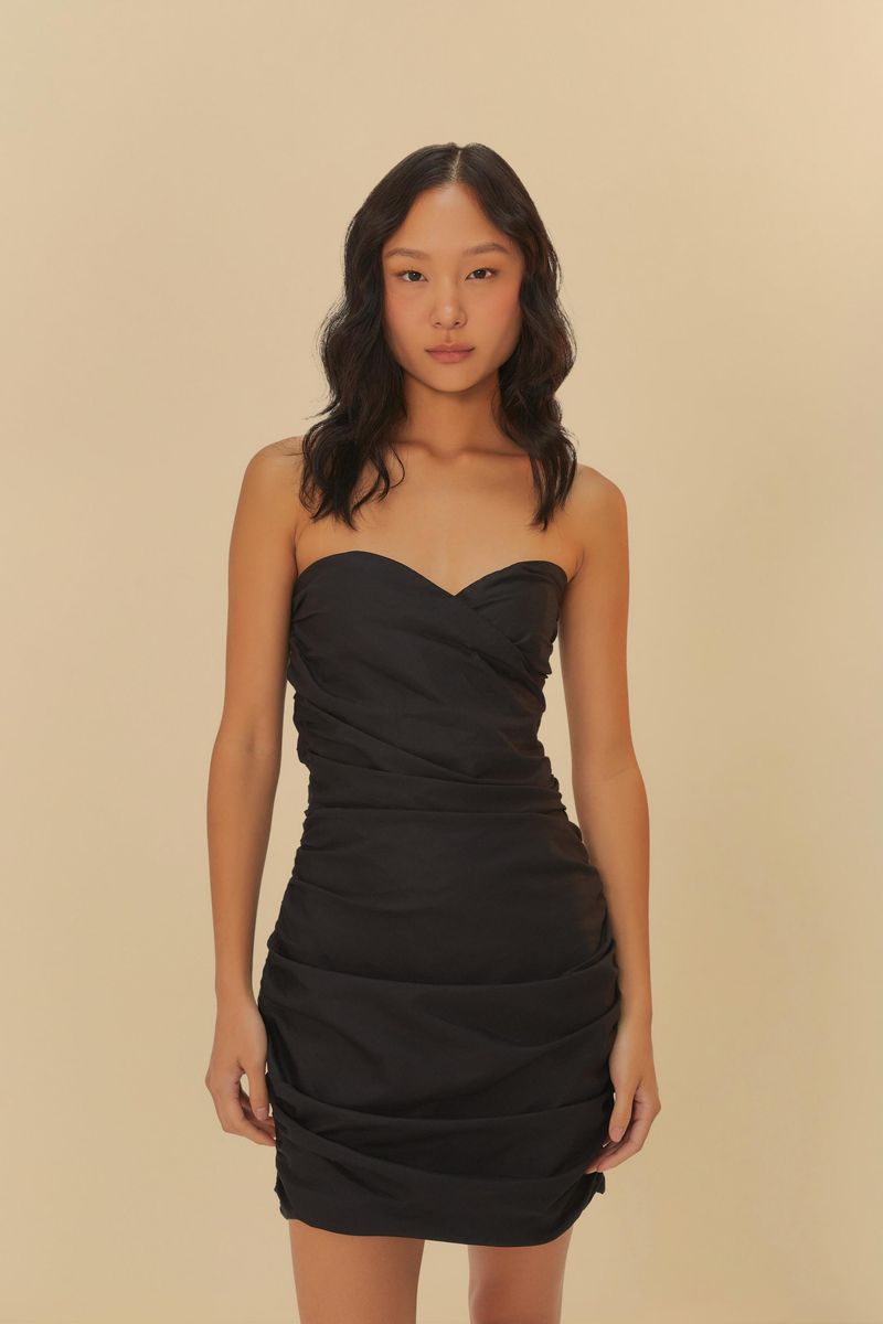 Vestido corto negro sin tirantes con fruncidos visto de frente, destacando el diseño ajustado.