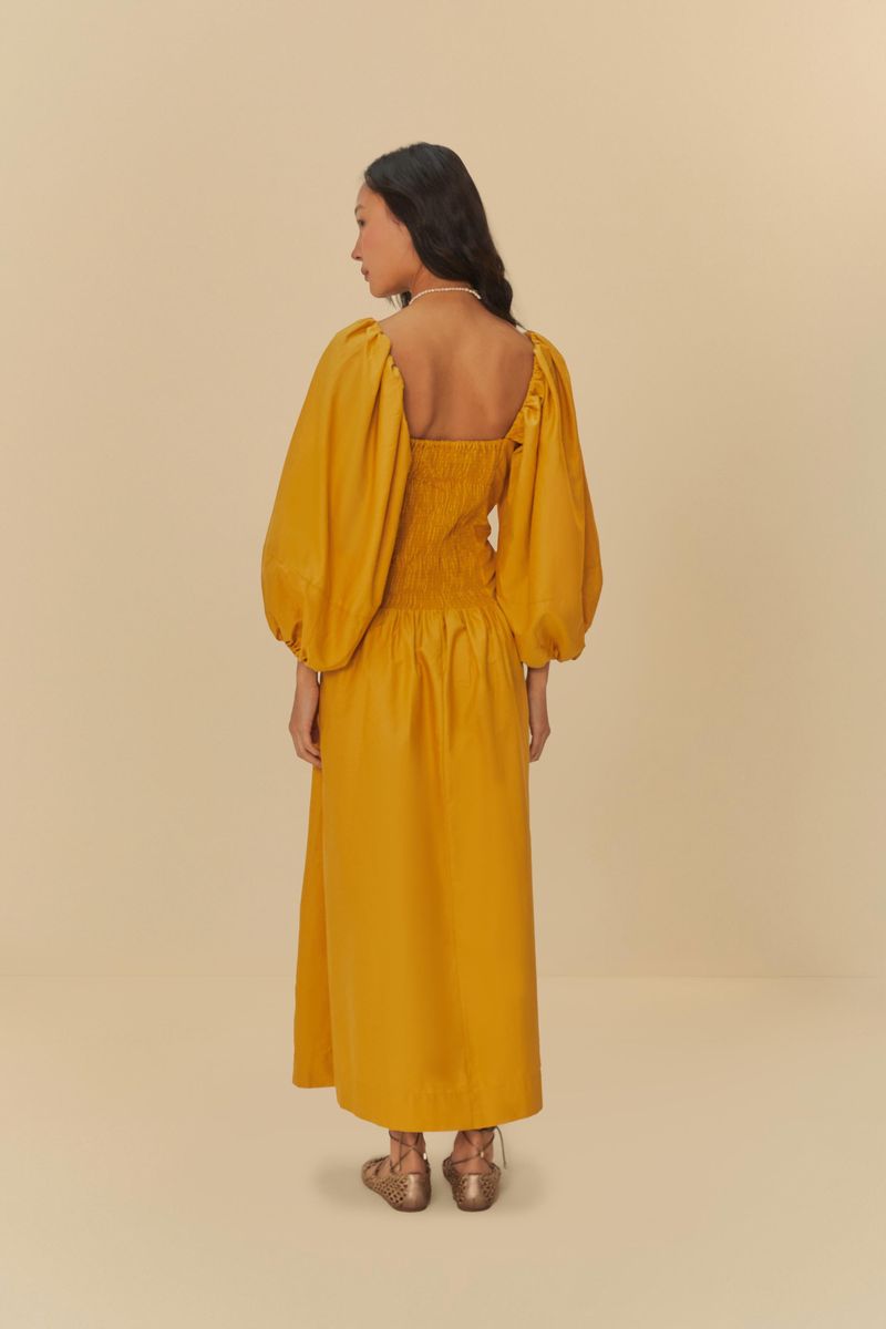 Vestido cropped con mangas abullonadas en tono amarillo, visto desde la espalda.