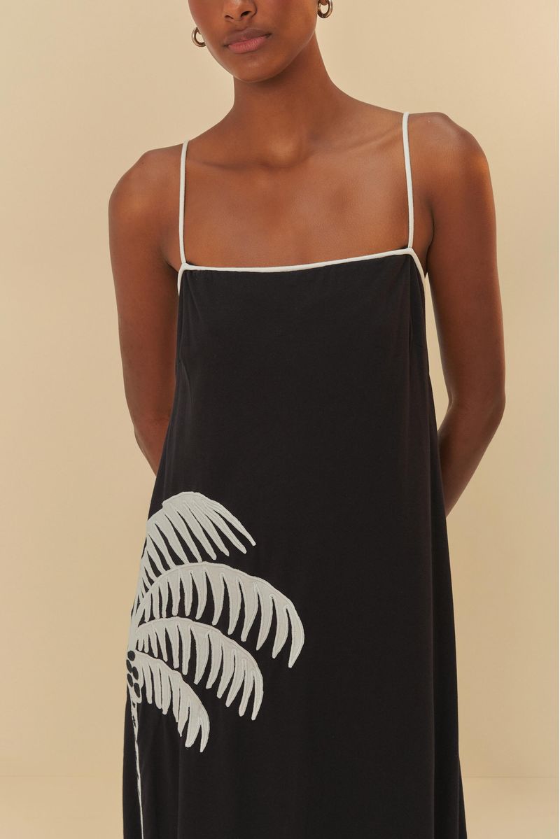 Vista-posterior-del-vestido-cropped-negro-con-diseño-de-palmera-blanca-tiras-delgadas-y-falda-larga.