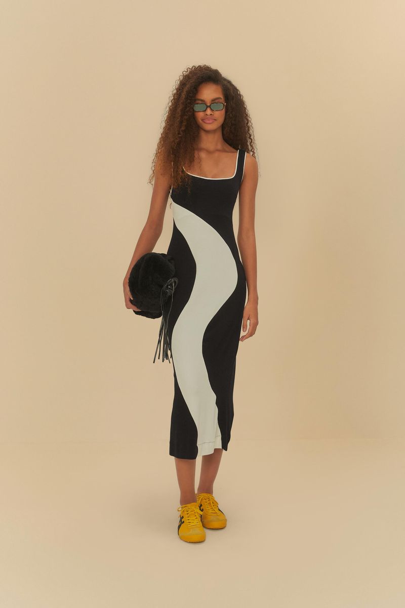 Modelo-con-vestido-midi-con-recortes-en-negro-y-blanco-sosteniendo-bolso-negro.
