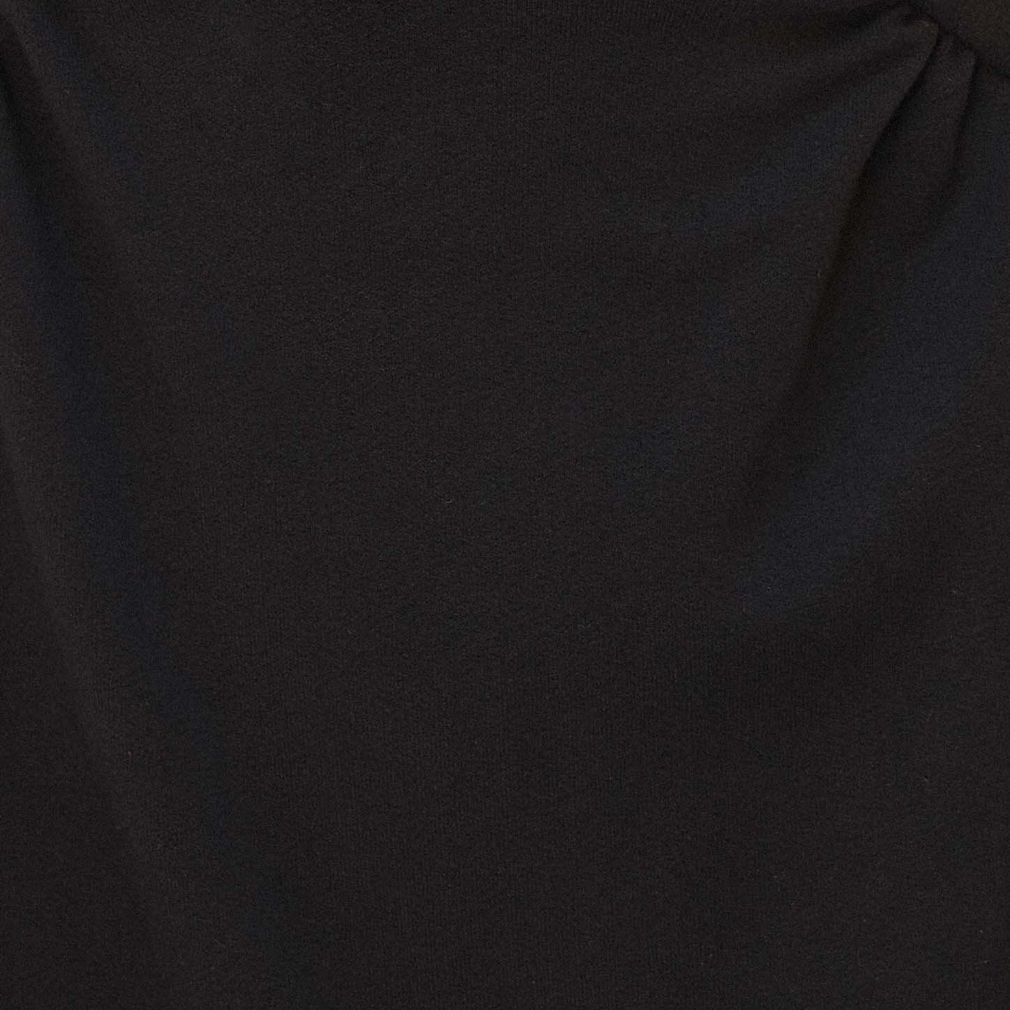 Acercamiento a la tela negra del vestido mostrando su textura.