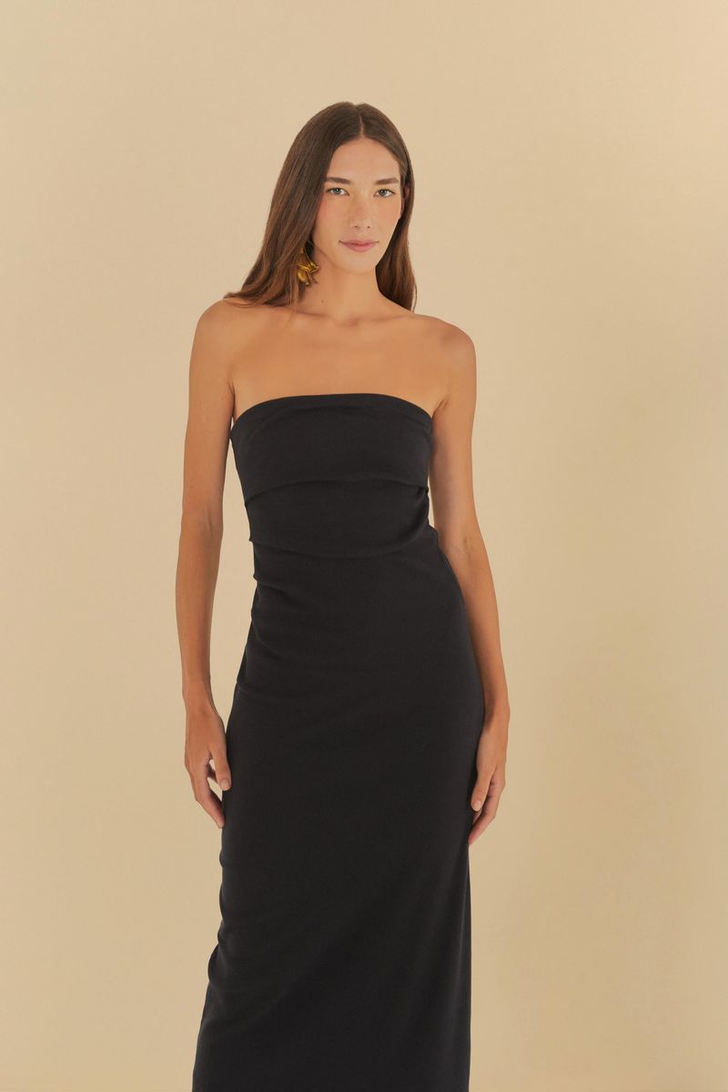 Modelo usando un vestido sin tirantes arrugado negro, vista lateral.