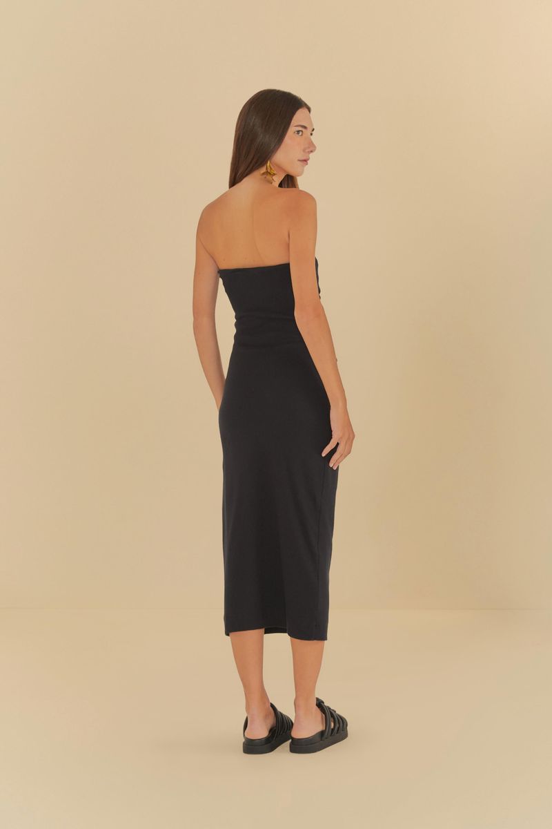 Modelo usando un vestido sin tirantes arrugado negro, vista trasera.