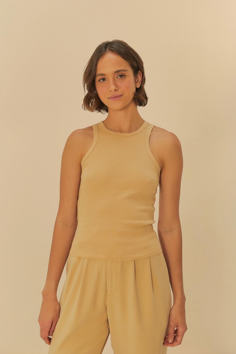 Imagen de una camiseta sin mangas beige vista desde el frente, destacando su diseño ajustado y cuello redondo.