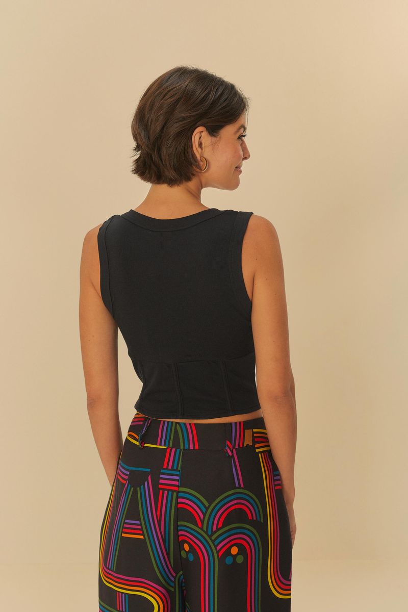 Imagen de una mujer vestida con una regata negra ajustada con escote en U, vista de espaldas.