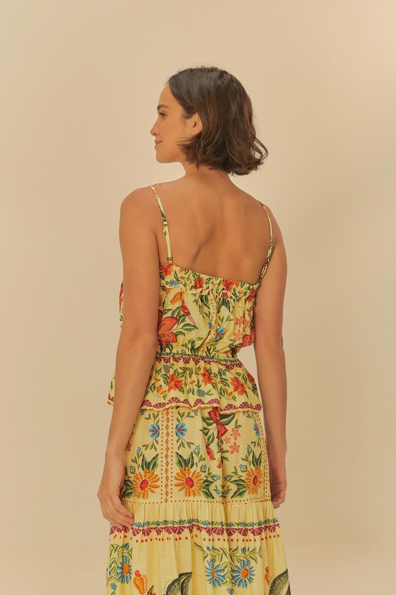 Vista posterior de la blusa, mostrando los tirantes finos y el diseño floral continuo.