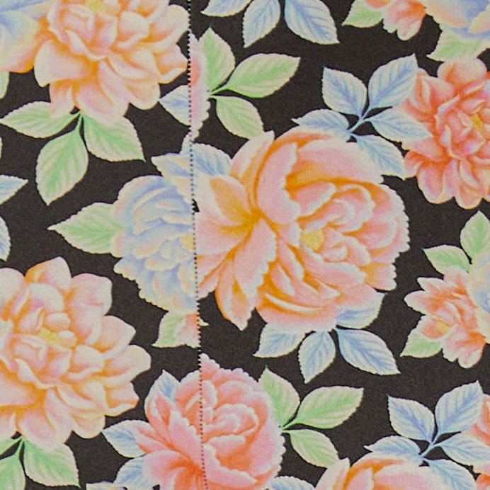 Imagen-de-unas-leggings-con-estampado-floral-sobre-fondo-negro-vista-frontal.