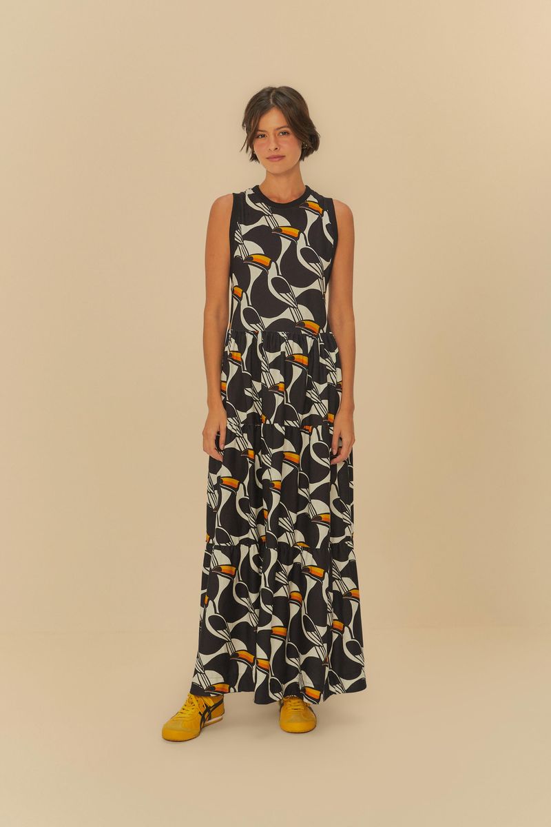 Vestido estampado con patrón geométrico sobre fondo negro, de largo extendido, diseño fluido y escote redondo.