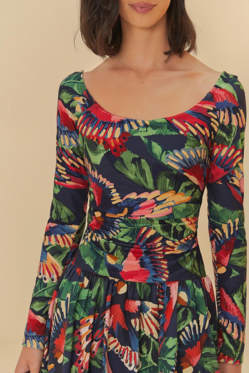 Detalle del vestido mostrando el patrón vibrante de estampas de pájaros y hojas.