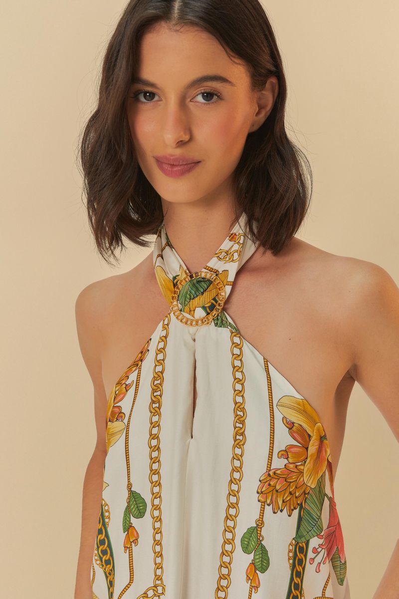 Detalle del cuello halter del vestido con estampado tropical.