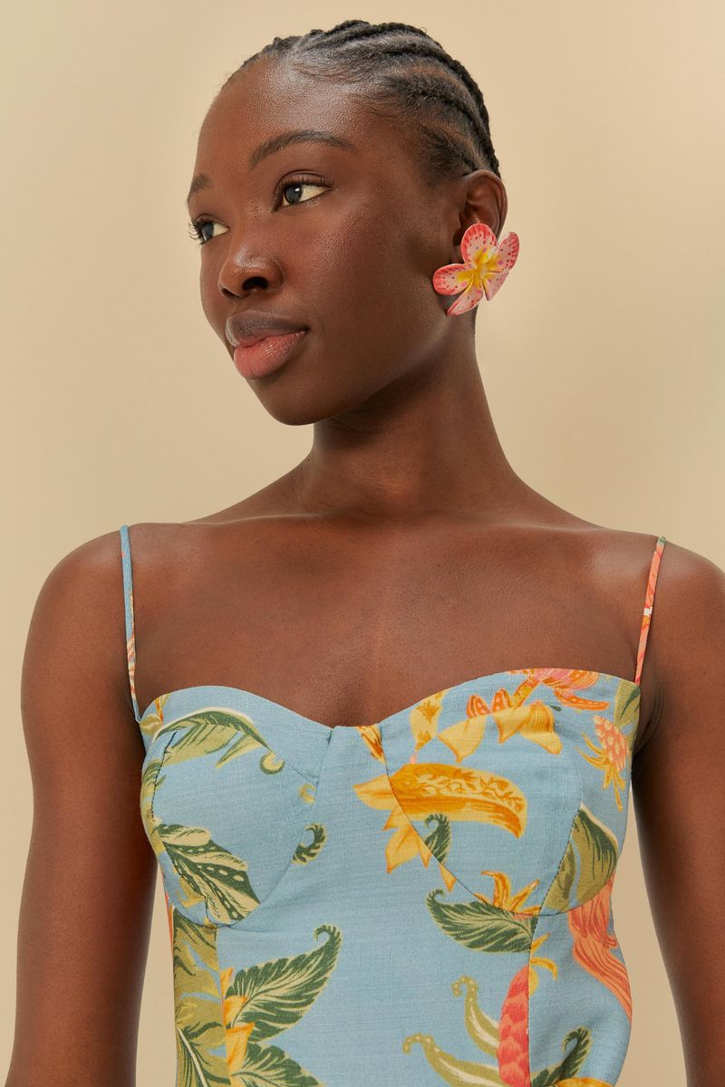 Detalle del corpiño del vestido cruzado con estampado tropical, mostrando tirantes delgados y escote en V.