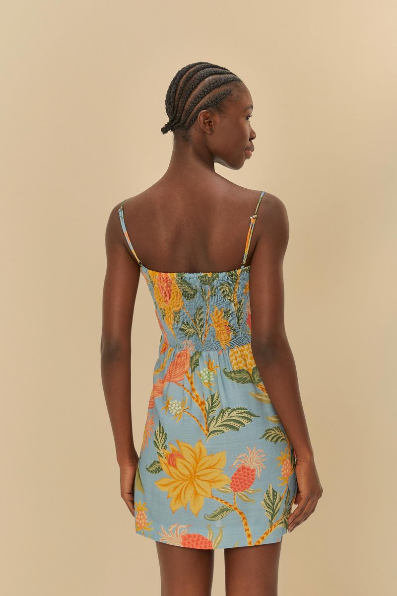 Vista trasera del vestido cruzado con estampado tropical, mostrando el ajuste en la cintura y tirantes delgados.