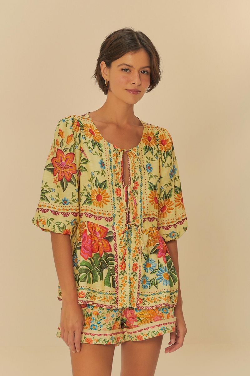 Modelo usando un conjunto de blusa y short estampado con motivos florales vibrantes.