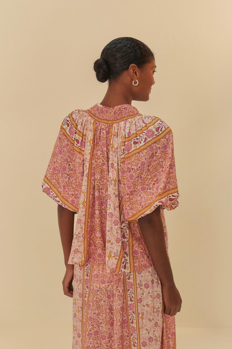 Imagen-de-una-blusa-estampada-con-detalles-florales-en-tonos-de-rosa-y-amarillo-vista-desde-atras.