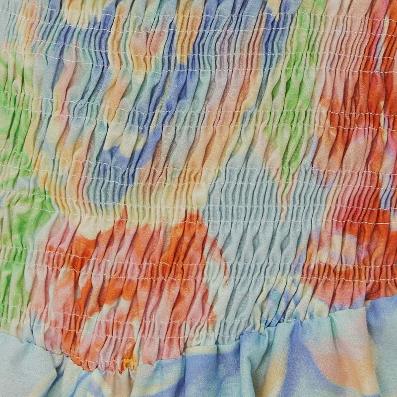 Close-up-del-estampado-floral-en-tonos-de-azul-claro-naranja-y-verde.