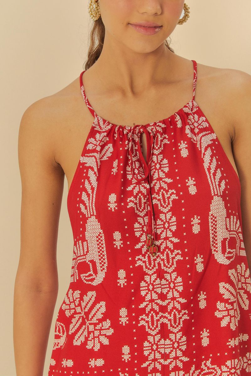Detalle del bordado tropical en la camiseta sin mangas roja.