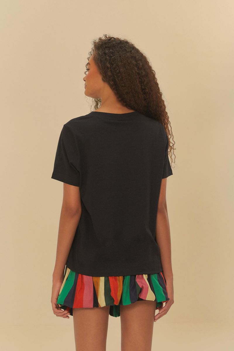 Vista trasera de la camiseta negra con estampado geométrico, mostrando la longitud hasta la cadera.