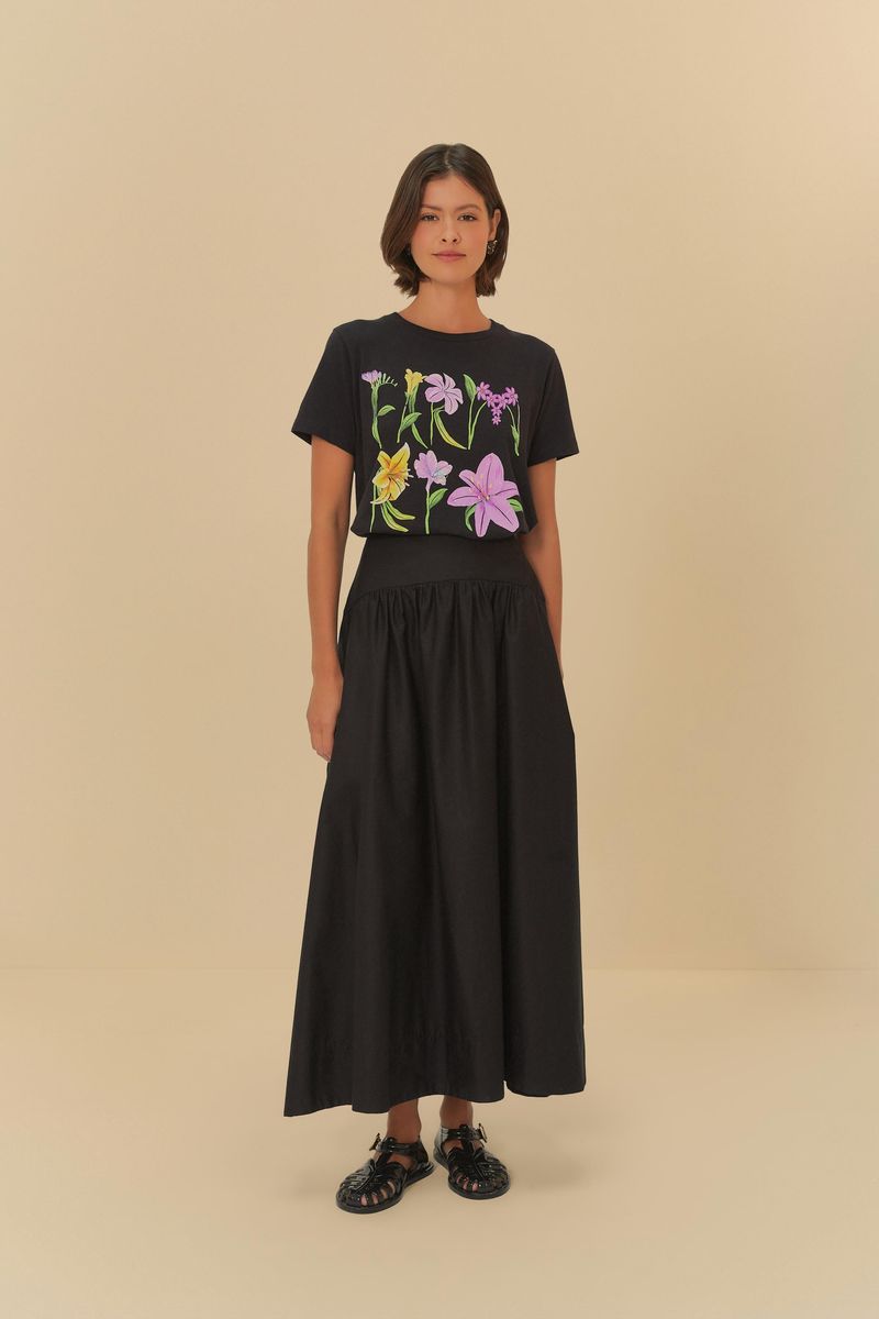 Modelo-de-cuerpo-entero-vistiendo-camiseta-floral-y-falda-negra-de-pie.