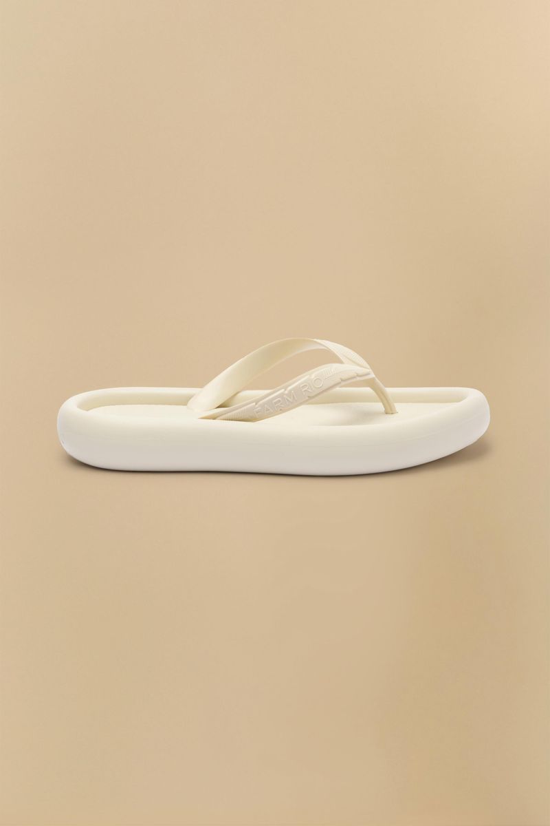 Imagen de una sandalia beige vista de lado, mostrando su diseño sencillo y cómodo.