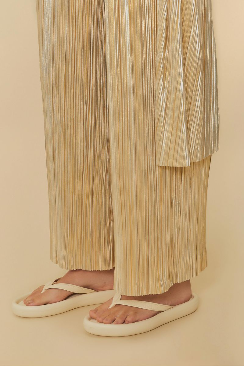 Imagen de una persona usando las sandalias beige con un atuendo dorado, mostrando el estilo casual.