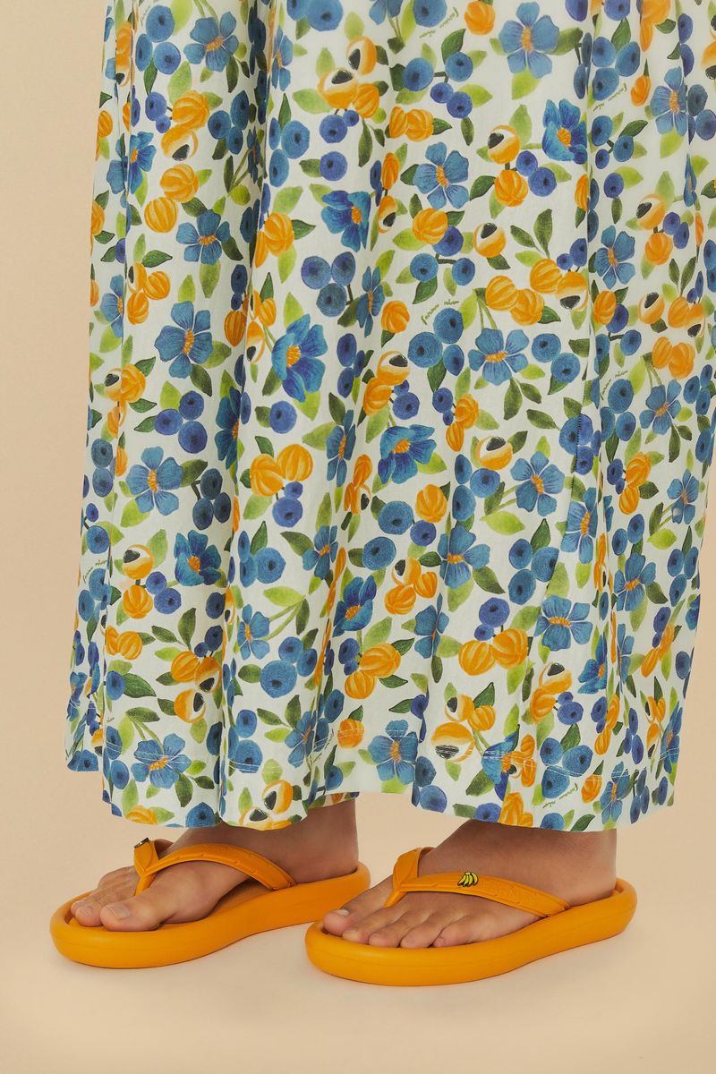 Close-up del vestido floral y chinelo Canoa Liso Con Pin en amarillo.