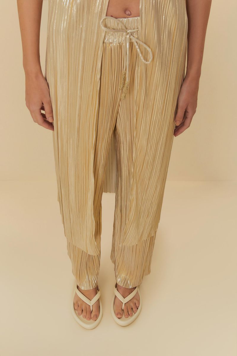 Imagen de una persona usando las sandalias beige con un atuendo dorado, destacando la comodidad.