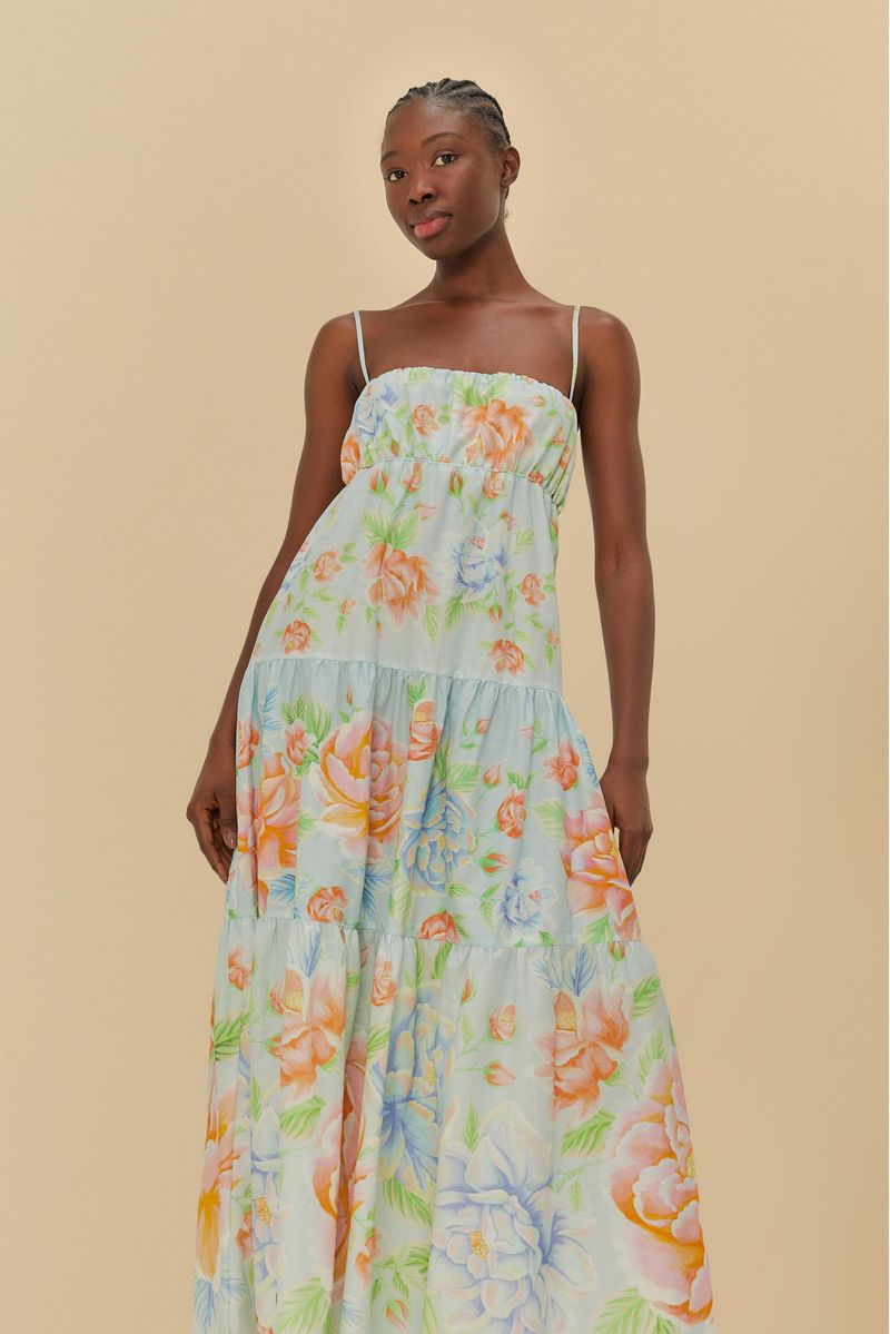 Vestido floral con tiras finas, largo por debajo de la rodilla y diseño vibrante, visto de lado.