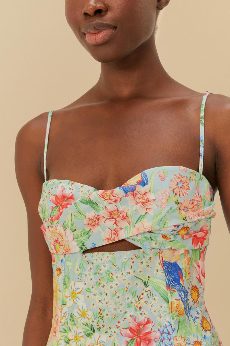 Primer plano del vestido mostrando el recorte frontal y el estampado detallado de flores y pájaros.