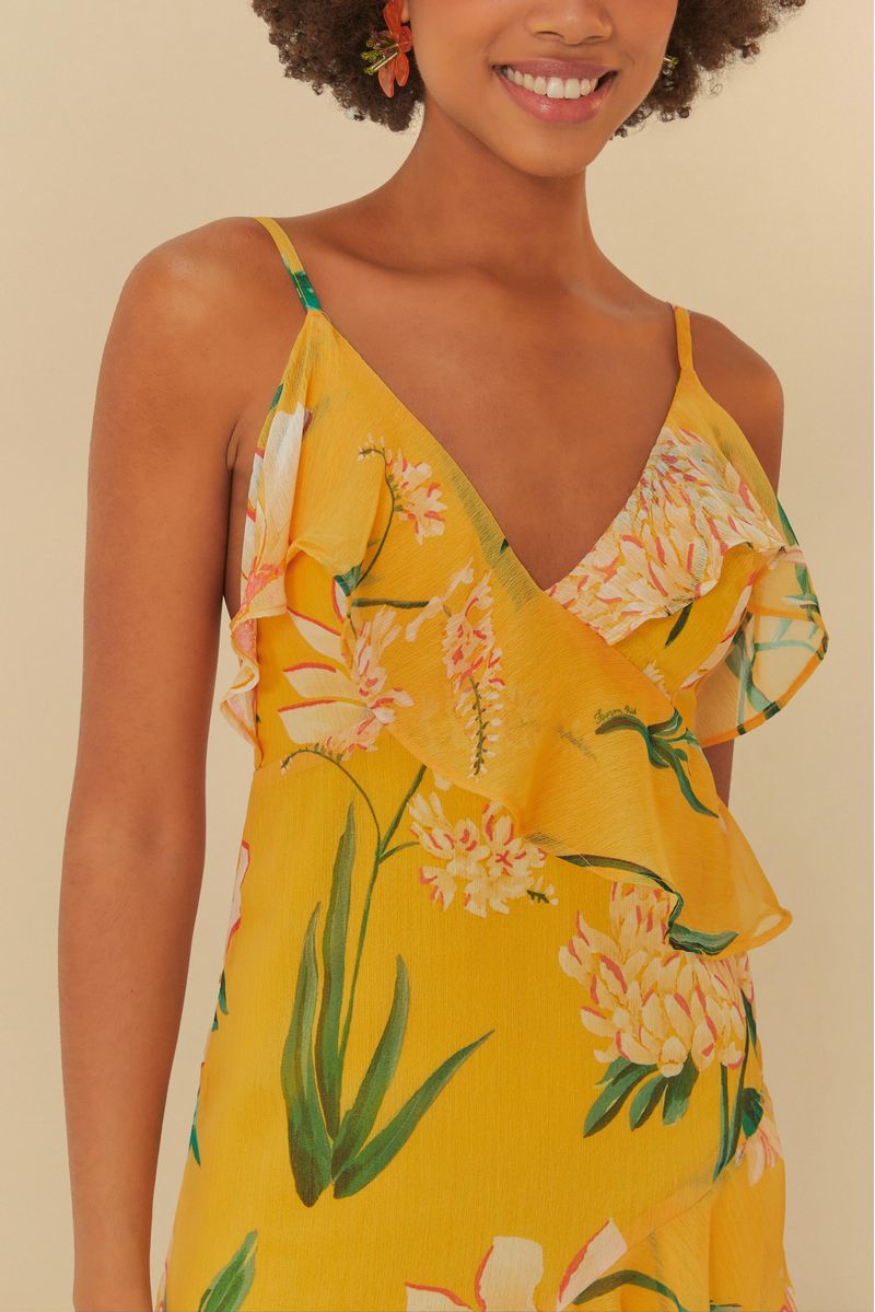Vestido amarillo con estampado floral y volantes, visto de espaldas.