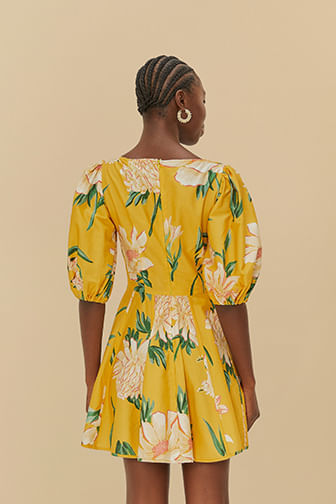Vista posterior del vestido corto floral con fondo amarillo, mostrando el diseño de la espalda.