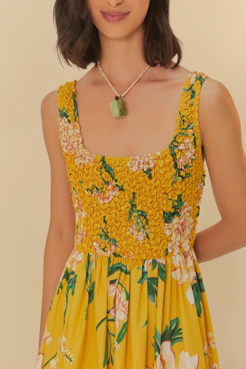 Detalle del corsé del vestido largo floral amarillo con textura y estampado de flores.
