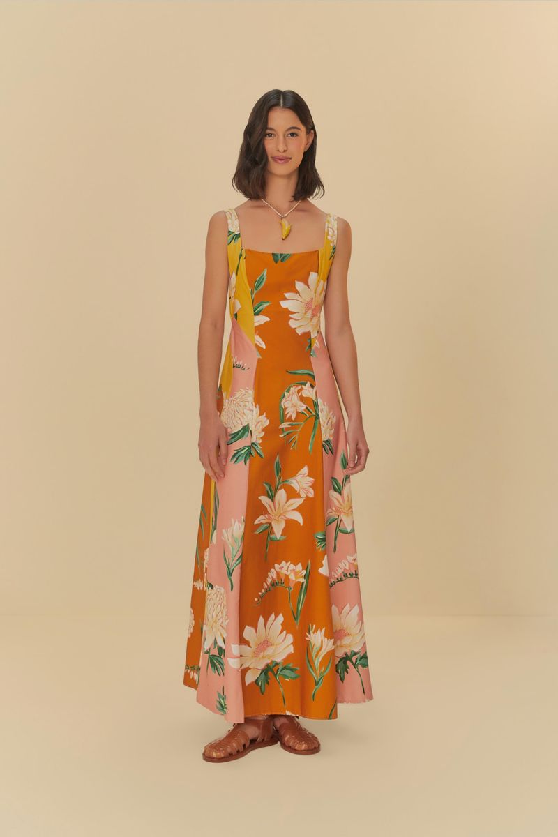 Vestido floral con tirantes anchos en fondo naranja y rosa, mostrado de frente.