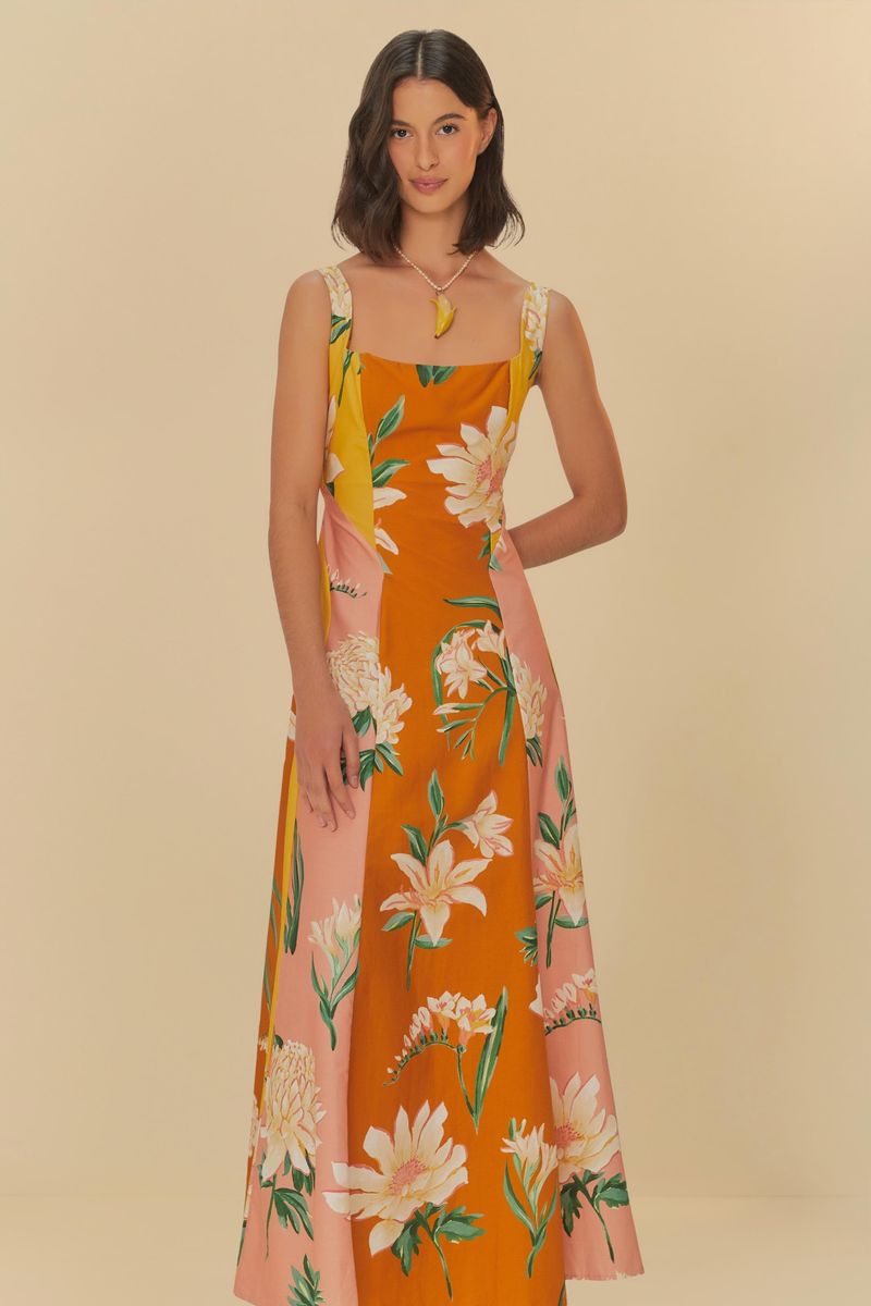 Vestido floral con tirantes anchos en fondo naranja y rosa, mostrado de lado.