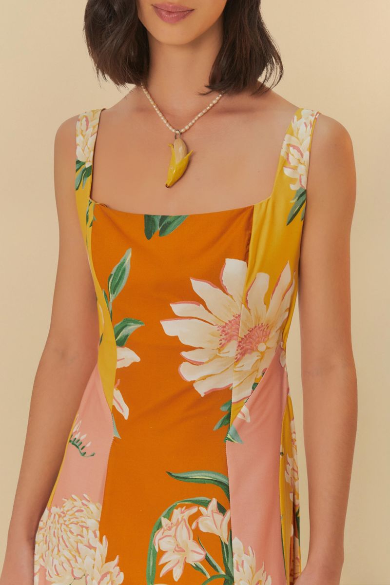 Detalle del escote cuadrado del vestido floral con fondo naranja y rosa.