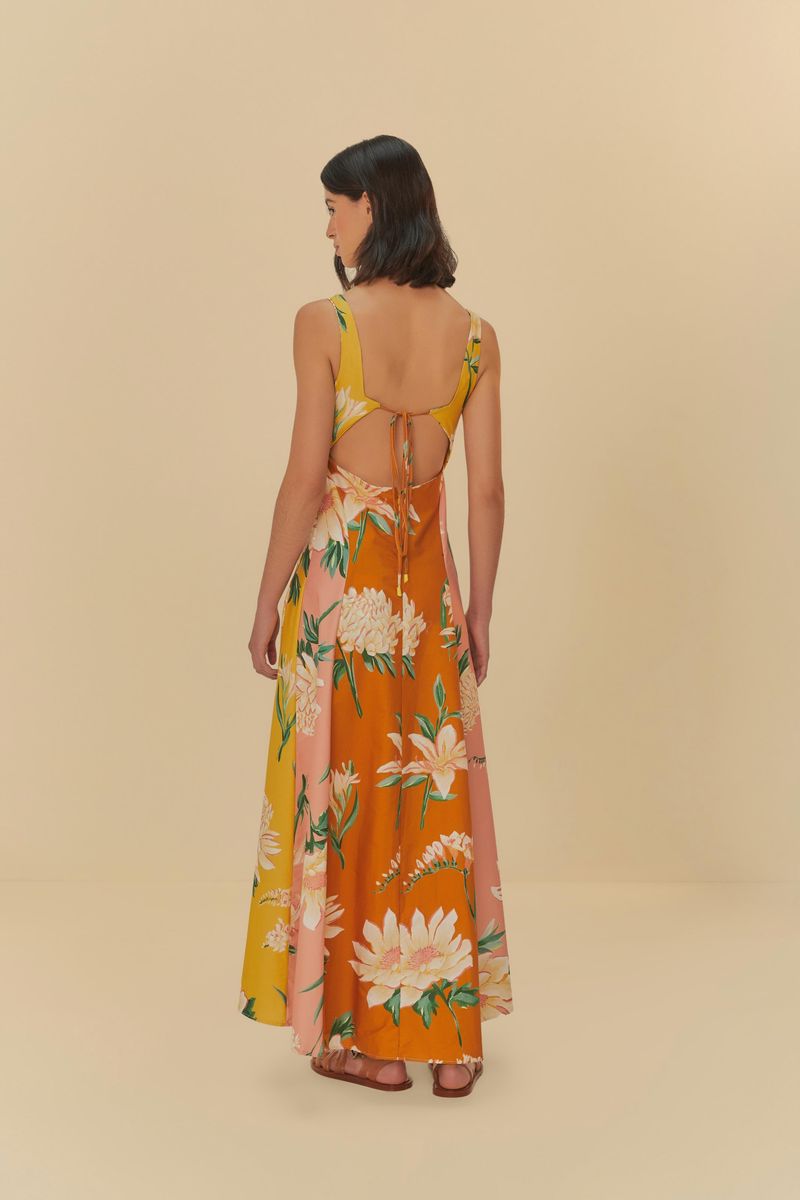 Vestido floral con tirantes anchos en fondo naranja y rosa, mostrado de espaldas.