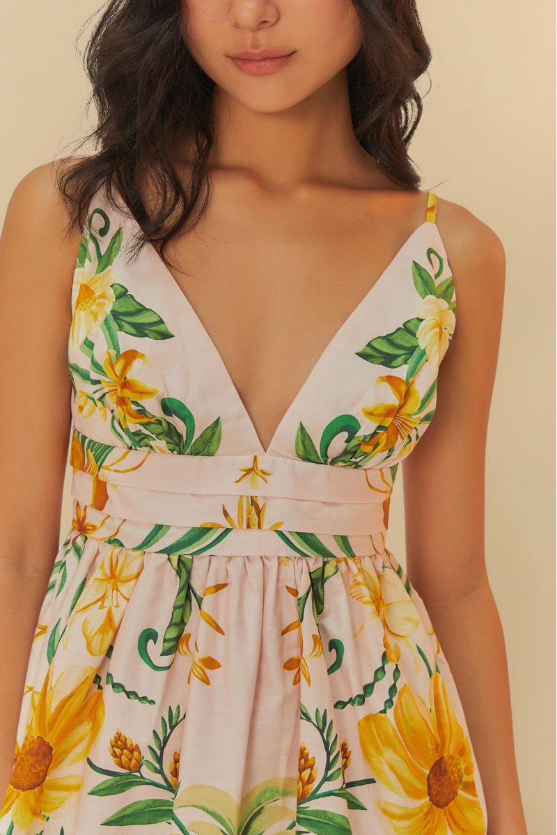 Primer plano del escote en V del vestido, destacando el estampado tropical con piñas y flores.