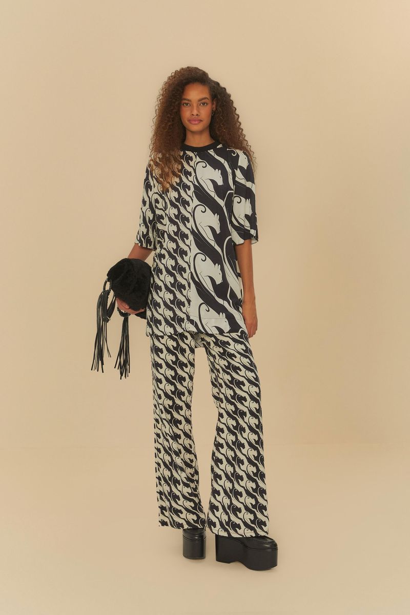 Modelo usando pantalón recto de sarga con estampado de panteras, combinado con una camisa estampada.