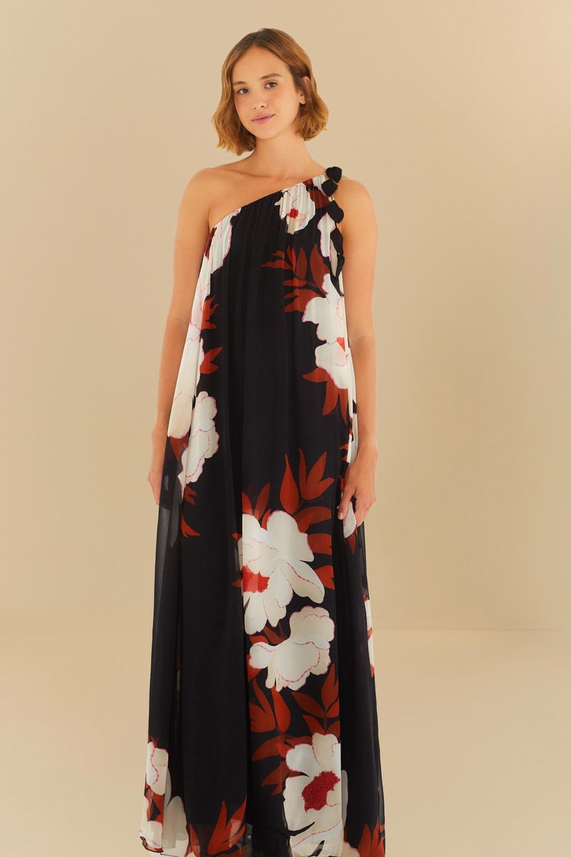 Vestido largo con estampado floral sobre fondo negro, modelo de un solo hombro, mostrado en pose lateral.