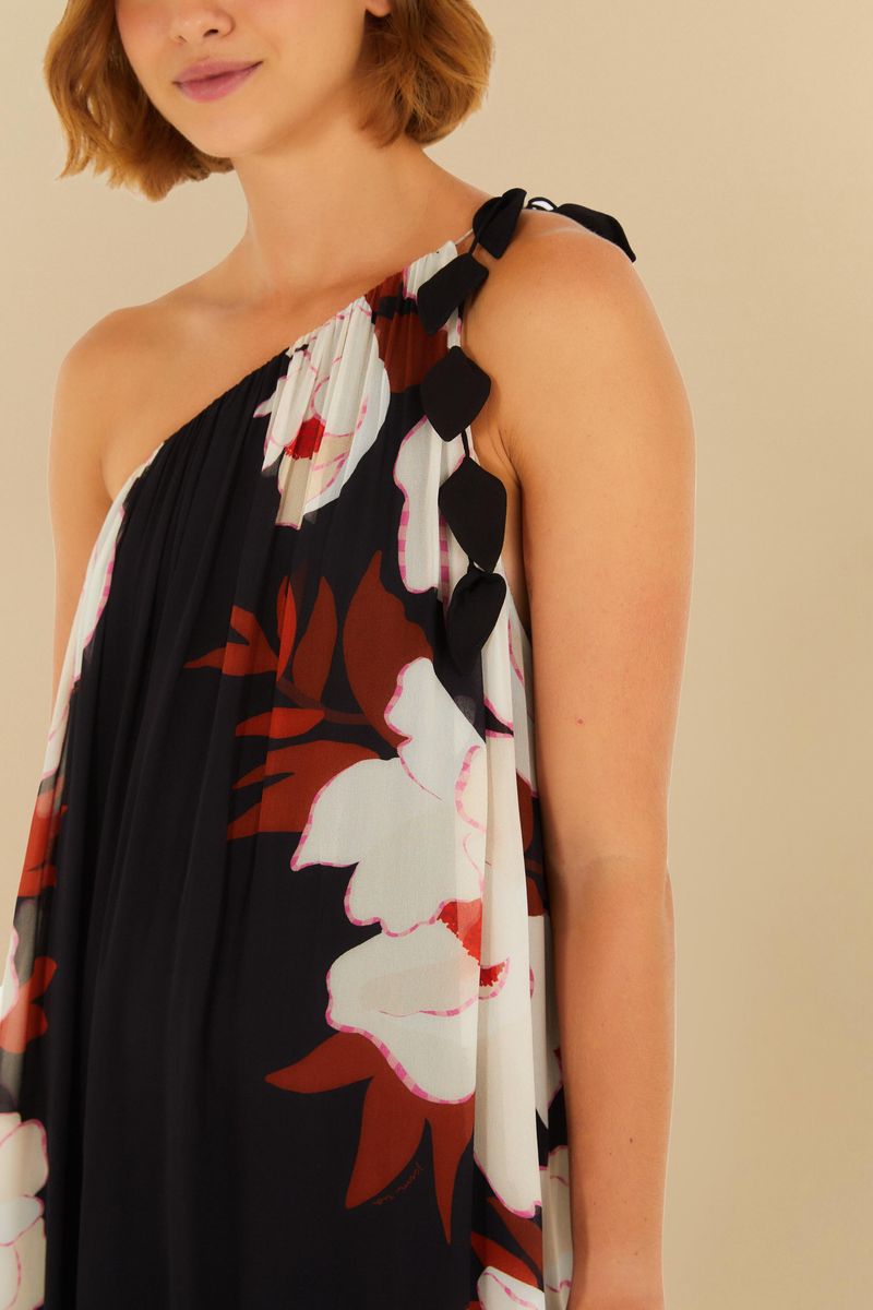 Vestido largo con estampado floral sobre fondo negro, modelo de un solo hombro, mostrado en pose trasera.
