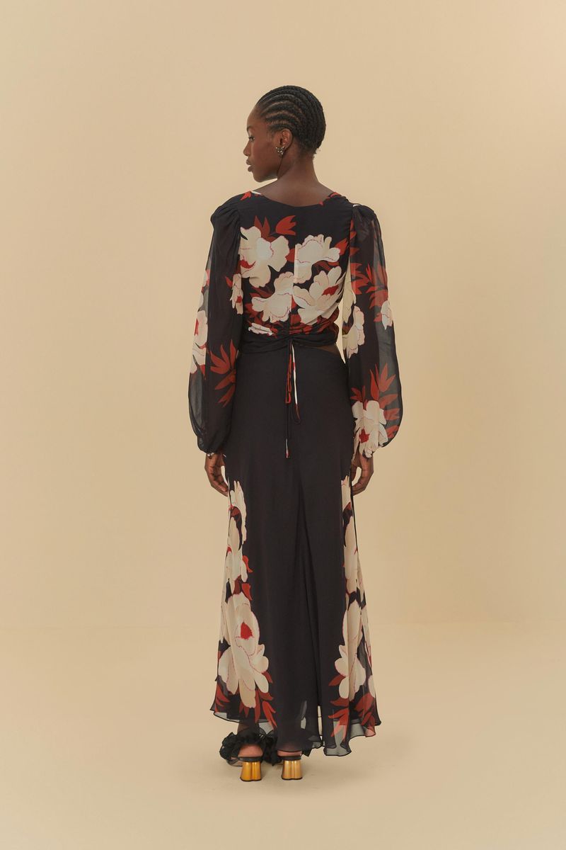 Modelo-de-espaldas-usando-falda-midi-negra-con-estampado-floral-y-fleco.