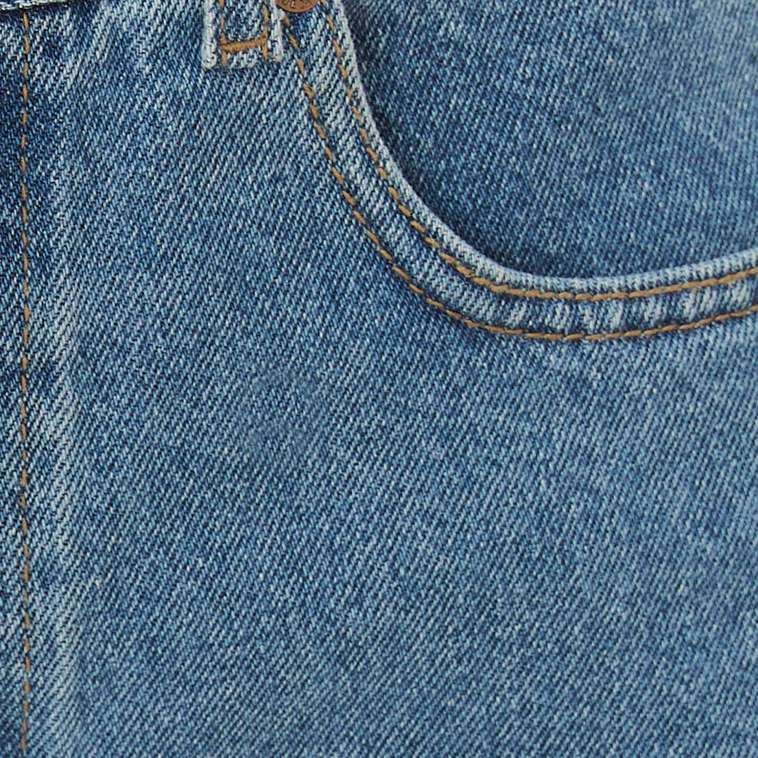 Detalle-de-la-tela-del-short-de-mezclilla-curvo-desgastado-mostrando-la-textura-del-denim.