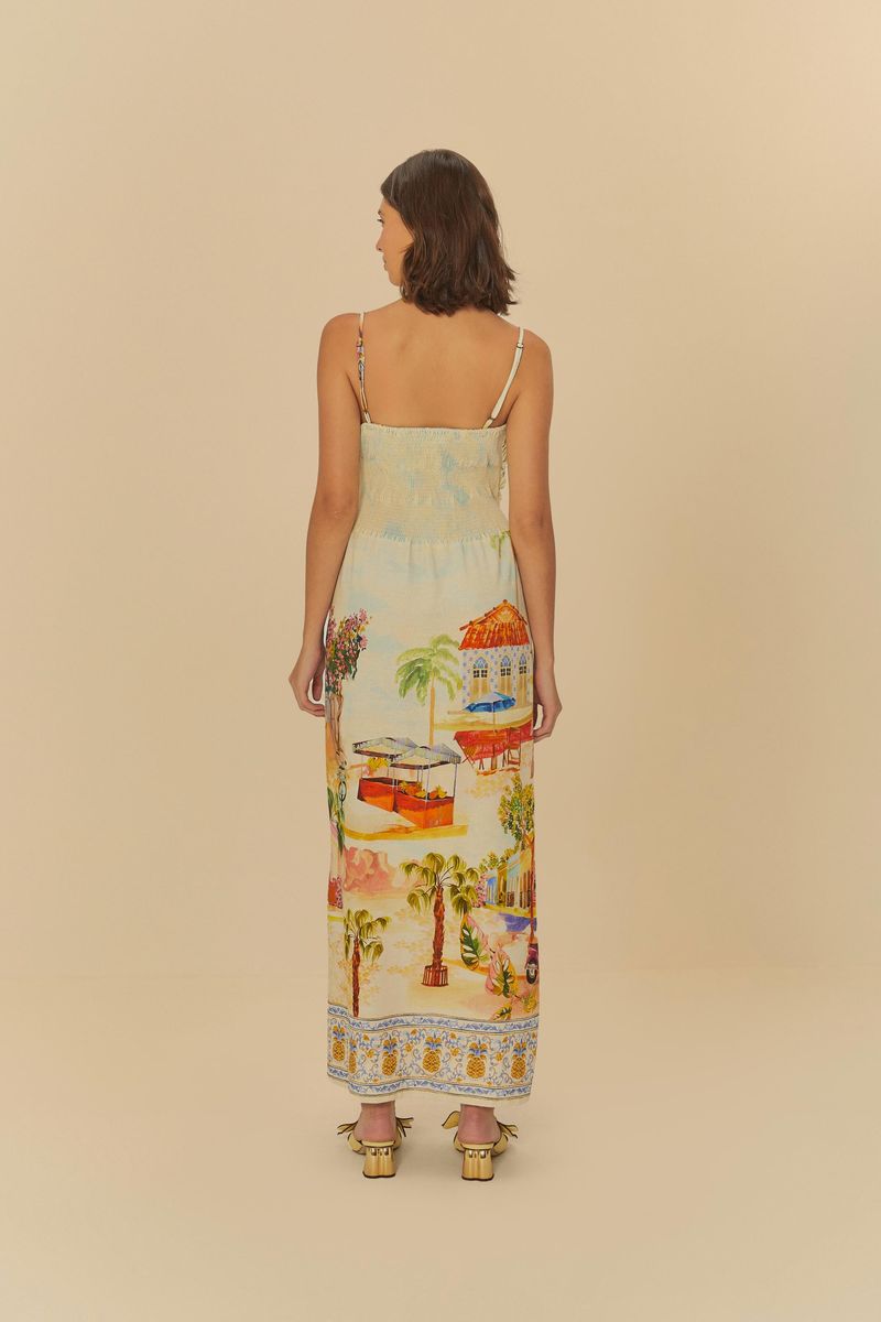 Vestido largo con estampado tropical, tiras delgadas y escote cruzado, visto de espaldas.